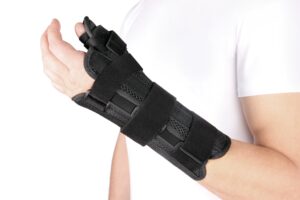 A person wearing a black brace after a wrist and thumb injury.