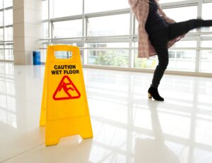 Person slipping on a wet floor before suffering a thumb fracture.